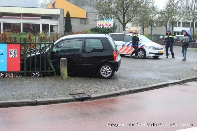 Auto slipt van de weg in Huizen en eindigt in een hekwerk