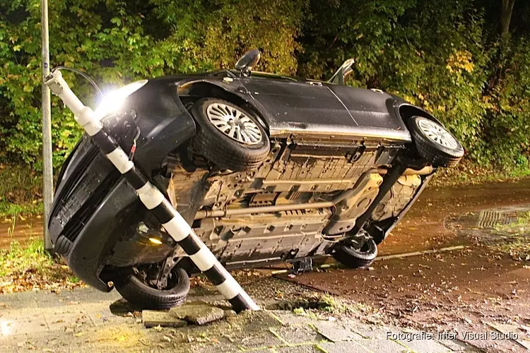 Auto rijdt stoplicht uit de grond in Huizen