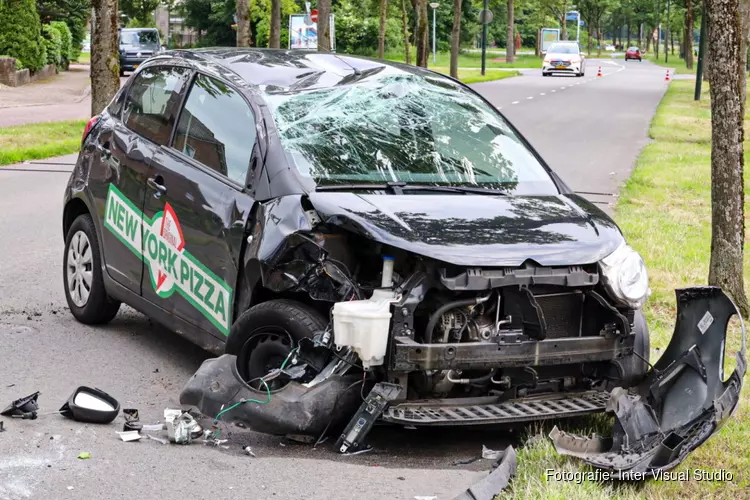 Pizzabezorger knalt met auto tegen boom en gaat over de kop in Huizen