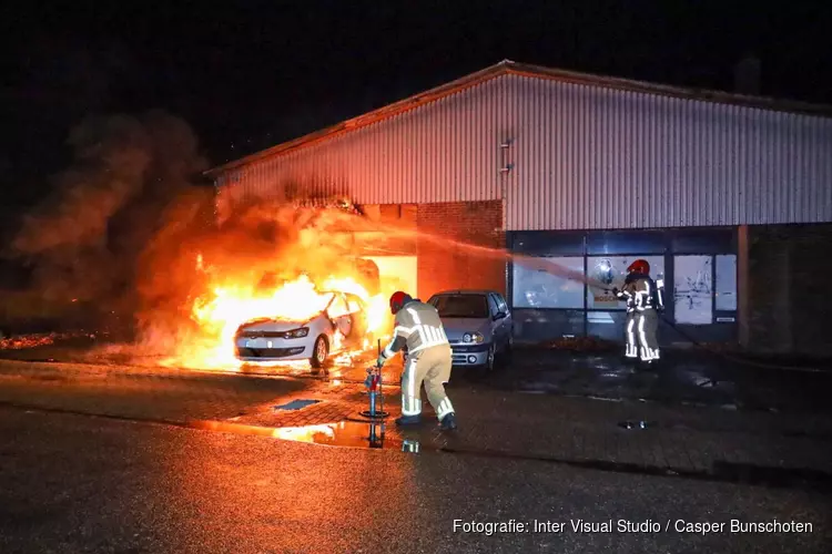 Auto en loods vatten vlam in Huizen