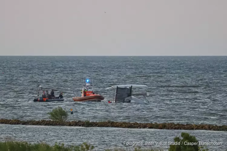 Catamaran omgeslagen vlak voor haven van Muiden