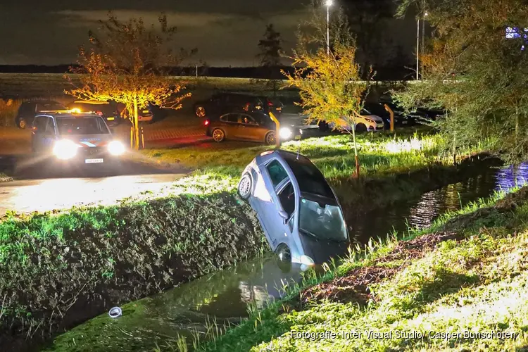Auto rijdt vanaf parkeerplaats te water in Weesp