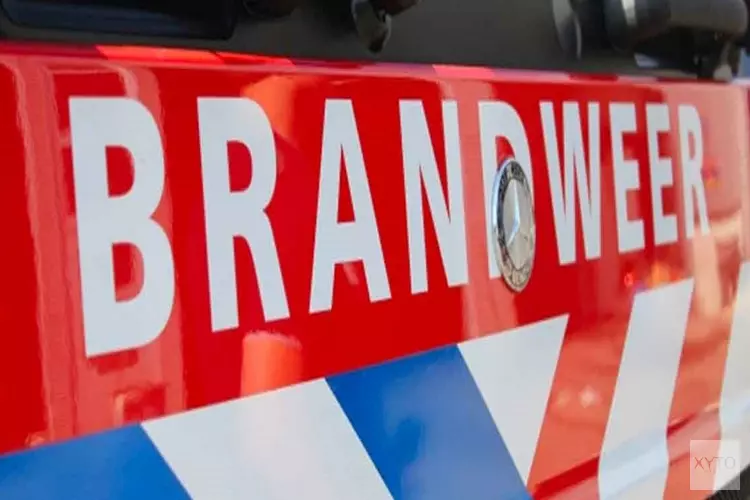 Auto in brand pal naast tankstation in Naarden