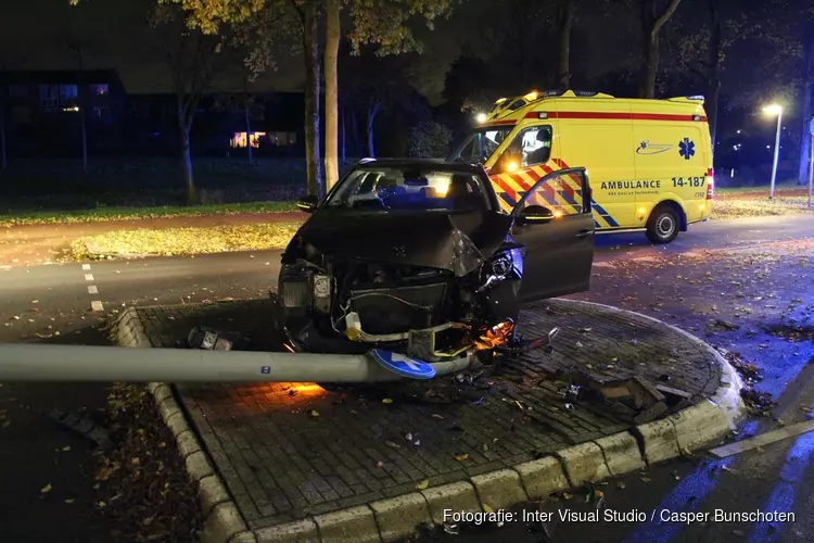 Auto tegen lantaarnpaal in Huizen