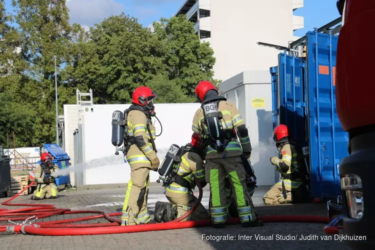 Brandweer haalt gasflessen uit brandende container